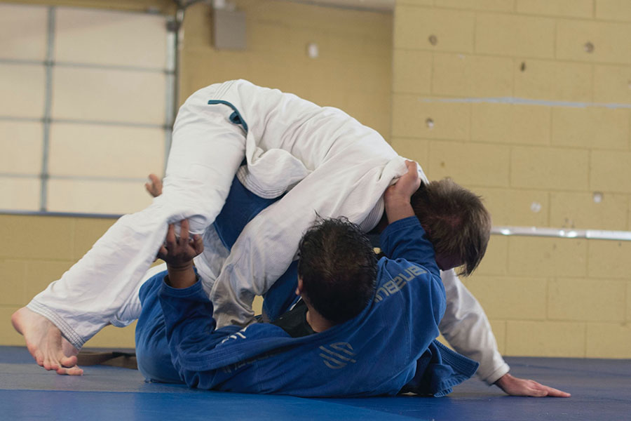 Compétiteur s'affrontant au judo sur un tatamis. 